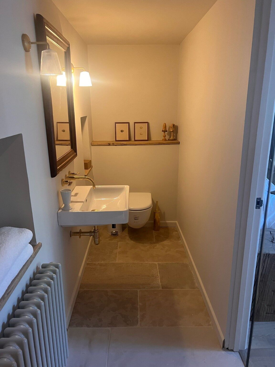 Compact cloakroom with stone floor and wall-mounted fittings