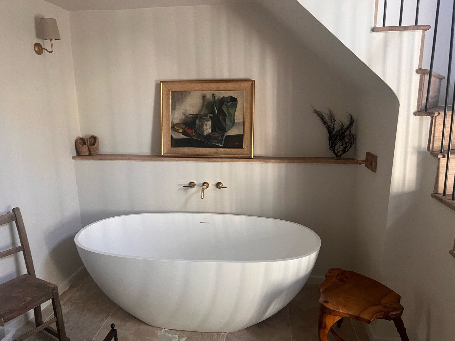 Completed bathroom with freestanding bath and bespoke staircase